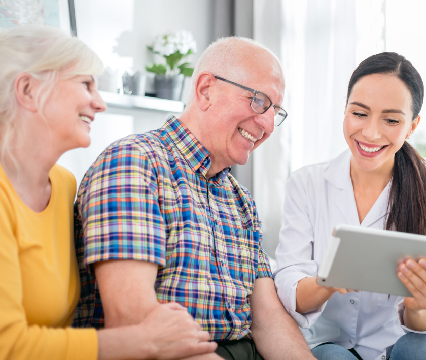 Nurse showing couple medical report using tablet