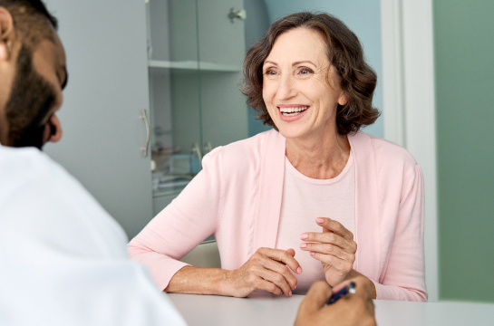 Smiling woman speaking with doctor